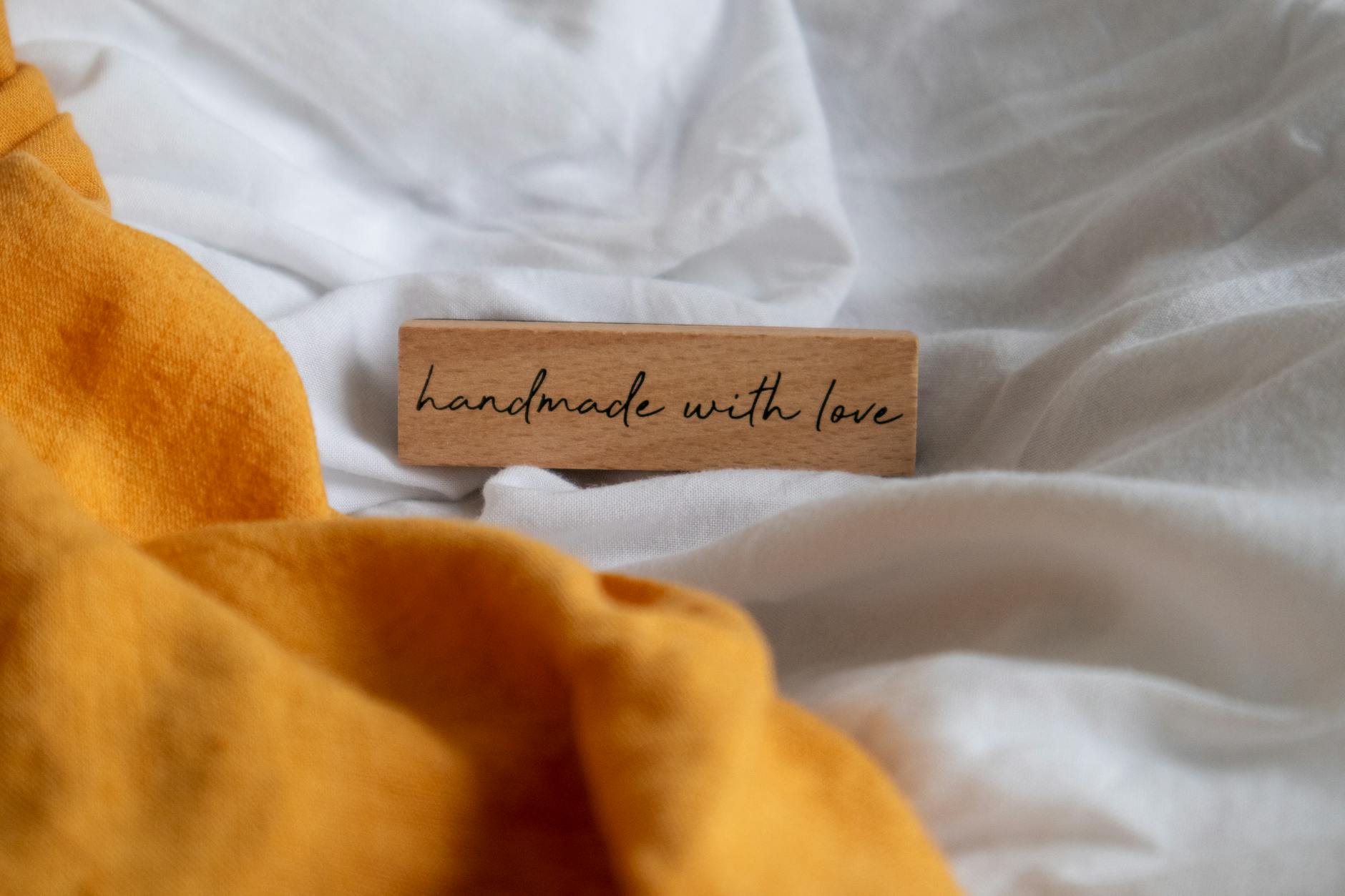 Drewniana tabliczka handmade with love na pomarańczowej pościeli z lnu