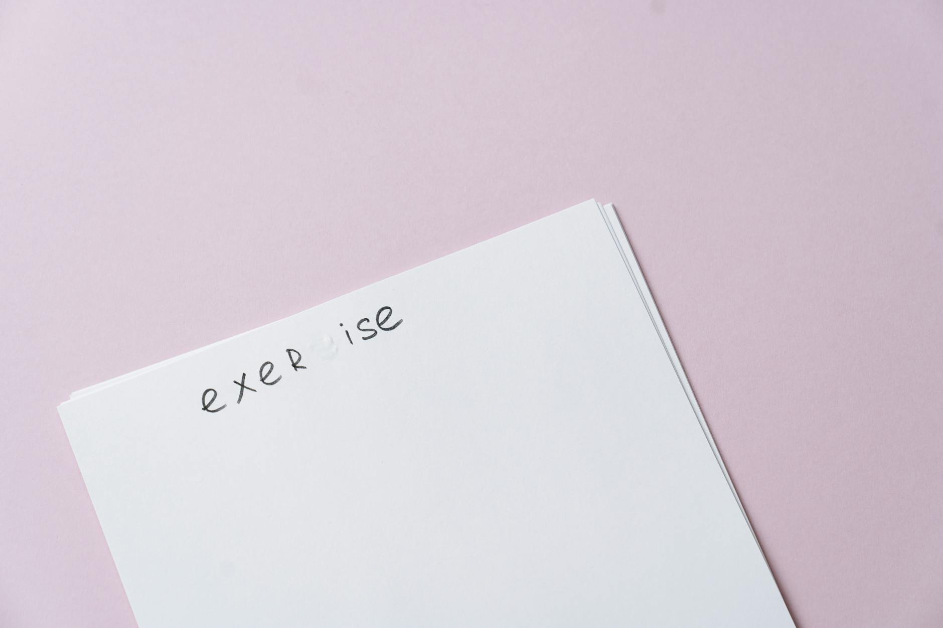 Najczęstsze błędy w tekstach zaproszeń i jak ich uniknąć Pusta biała kartka na różowym tle, gotowa na tekst zaproszenia