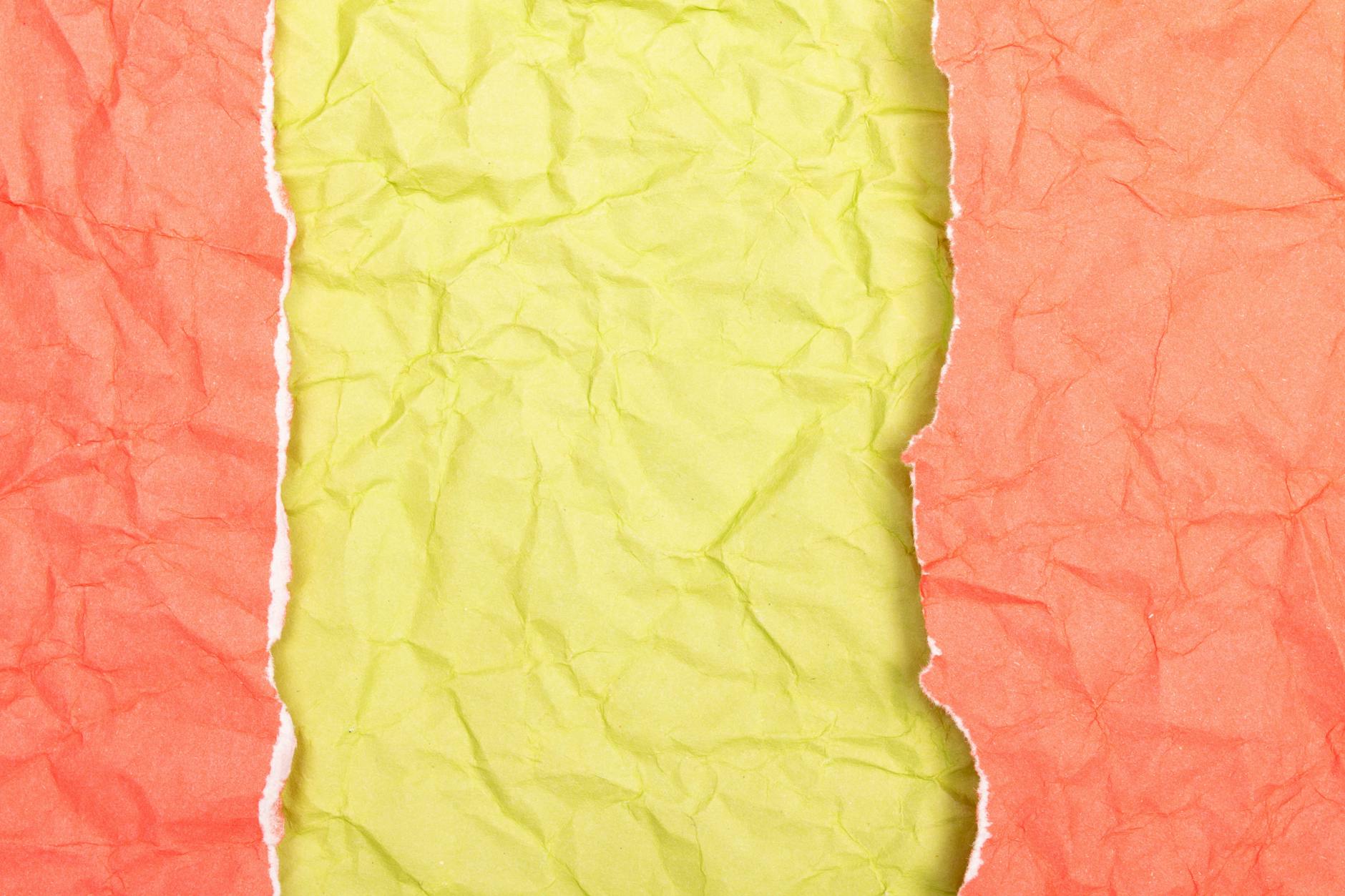 Pognieciony czerwono‑żółty papier z wyraźnie postrzępioną krawędzią