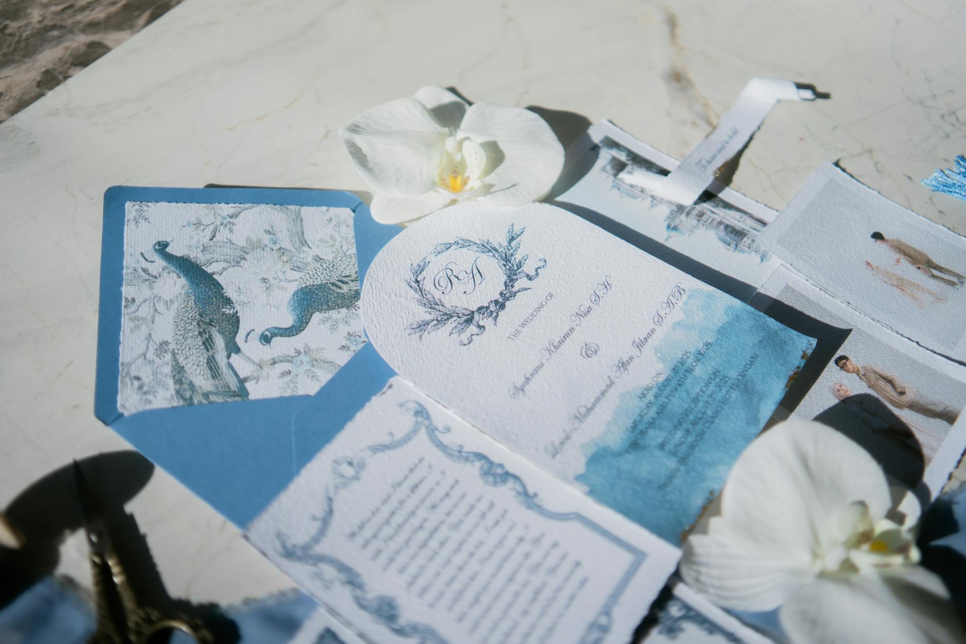 Zaproszenia ślubne glamour z motywem pawia i białymi orchideami